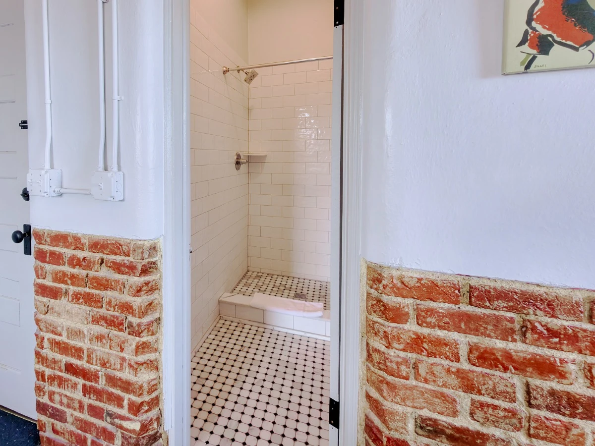 Standing shower in Room 113 at Hot Lake Springs Resort, tile interior with curtain pulled back.