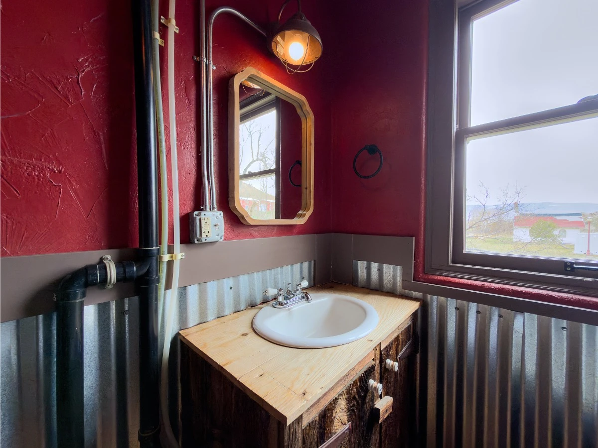 Bathroom sink with mirror in Room 207 at Hot Lake Springs Resort, window to the right of the sink.