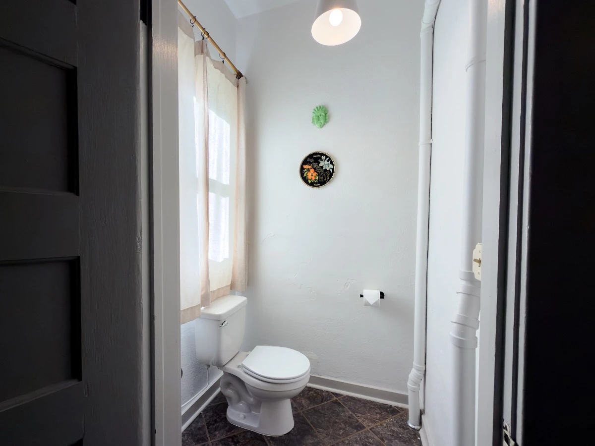 Bathroom in Room 218 at Hot Lake Springs Resort with toilet visible and window above it.
