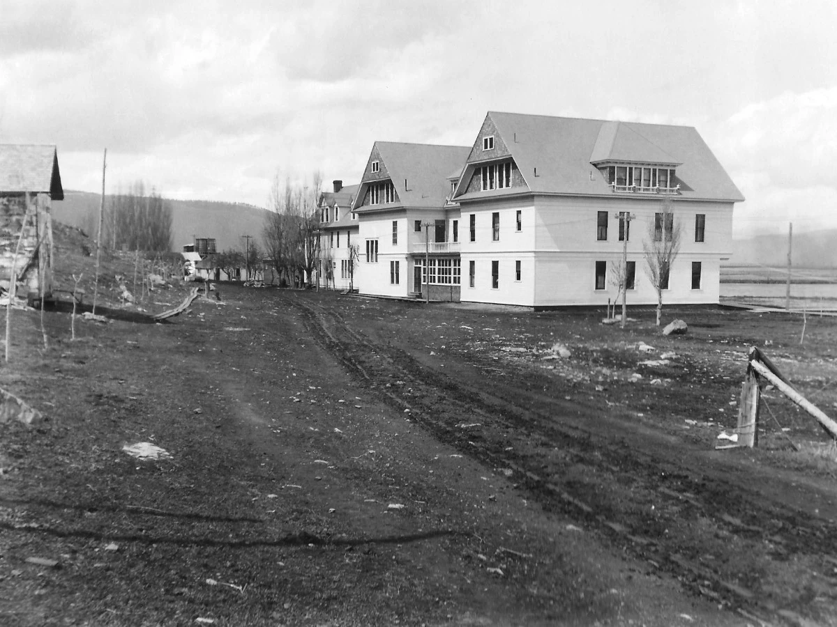 Early pre-brick construction view of Hot Lake Springs Resort, few wooden structures visible, photographed from future brick building site looking northwest.