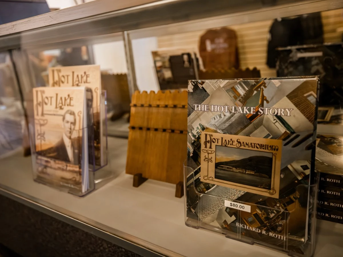Glass case display of multiple historical books in Hot Lake Springs Resort Gift Shop.