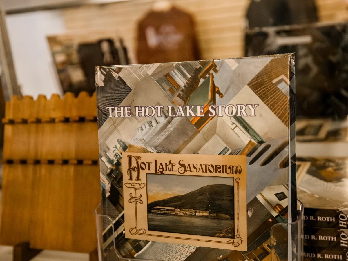 Close-up of "The Hot Lake Story" book displayed in glass case at Hot Lake Springs Resort Gift Shop.