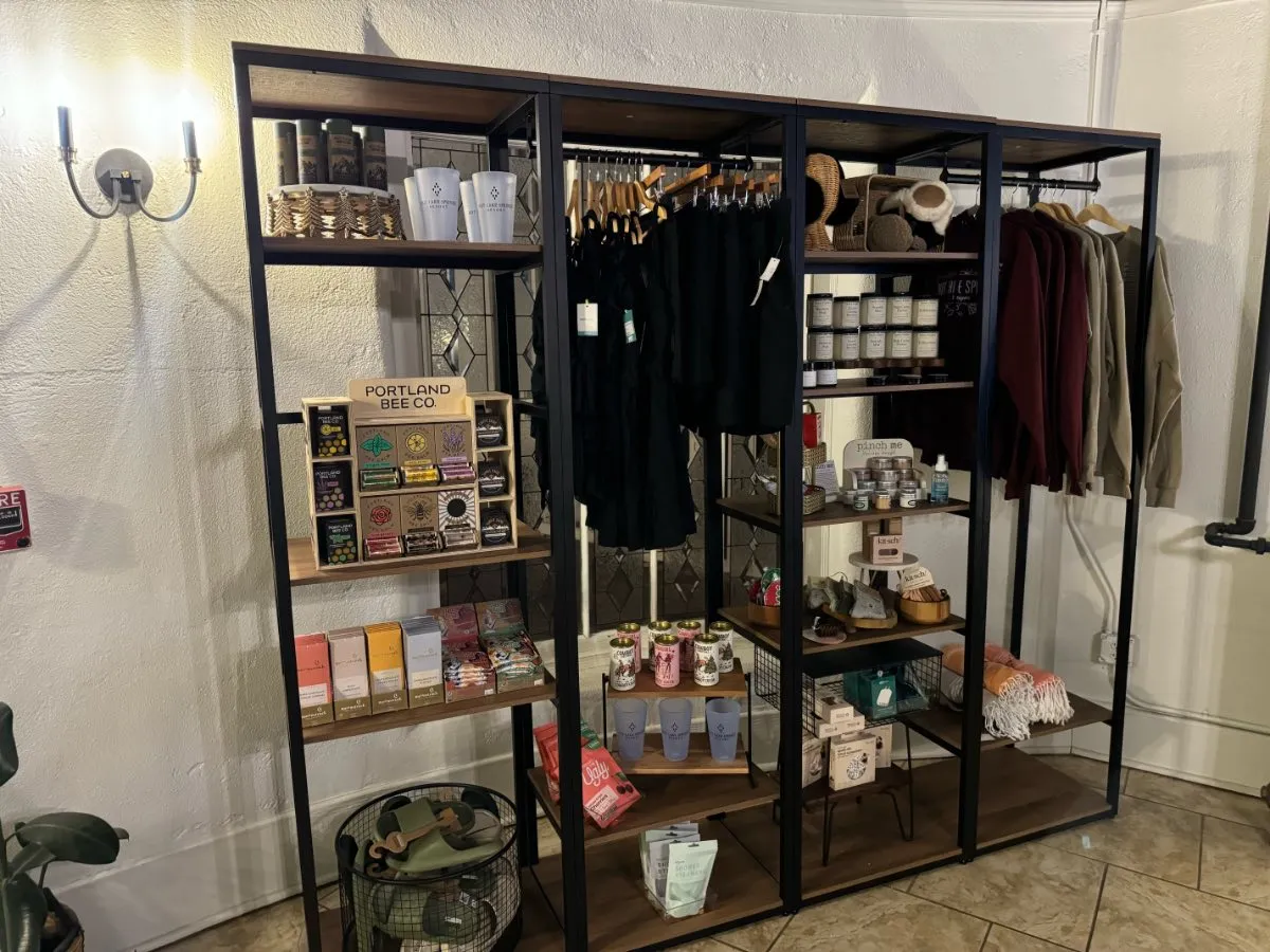 Popup lobby gift rack at Hot Lake Springs Resort entrance, small selection of souvenirs and items on display shelves.
