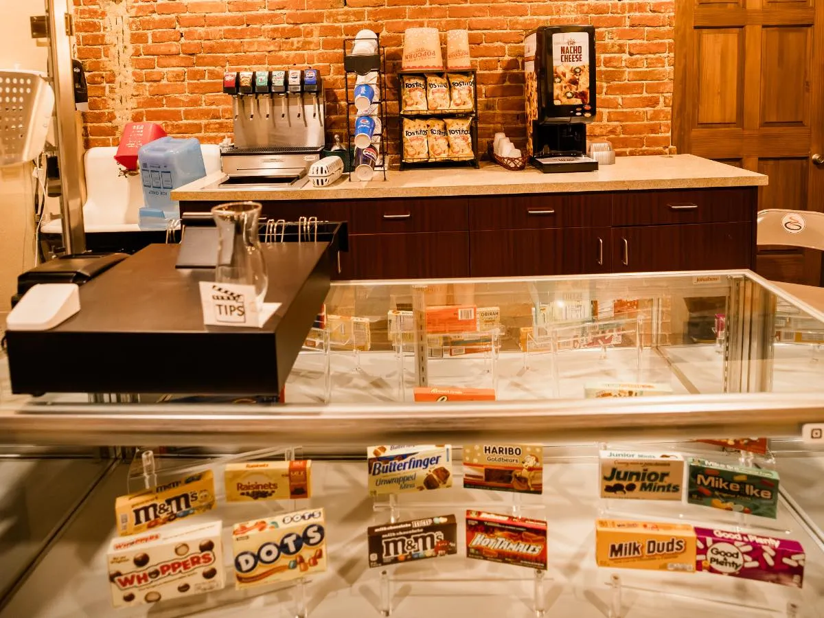 Small theater lobby at Hot Lake Springs Resort with candy display, soda machine, and nachos.